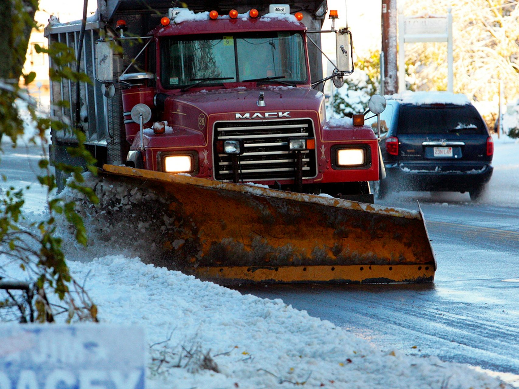 a snow plow driving down a snow covered road